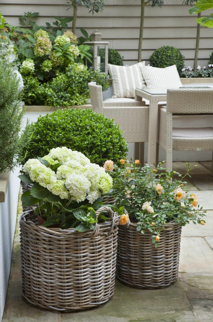 maceteros grandes, decoración de jardín con flores en macetas de canastas tejidas, mesa y sillas de rattan, plantas verdes