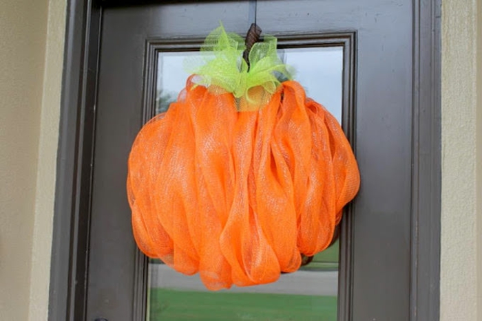 adornos halloween, calabaza de tela colgada en la puerta, decoración DIY simple, tela color verde y naranja