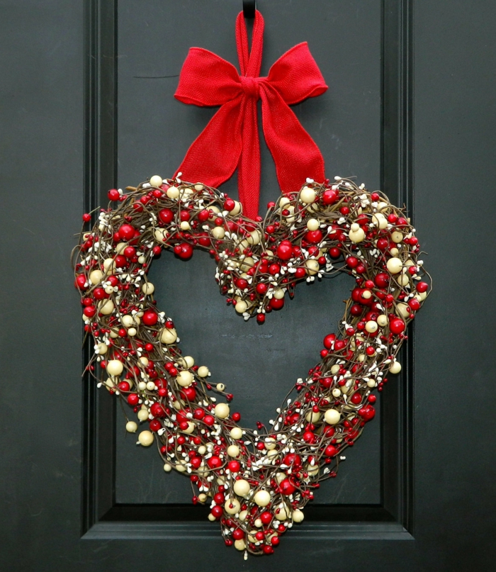 adornos de navidad caseros, corona navideña de muerdago blanco y rojo, forma de corazon, cinta roja