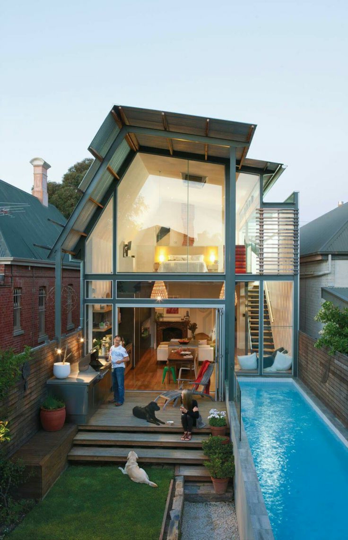 piscinas pequeñas, casa moderna con pared de vidrio, patio estrecho, piscina larga, hombre y niño, dos perros