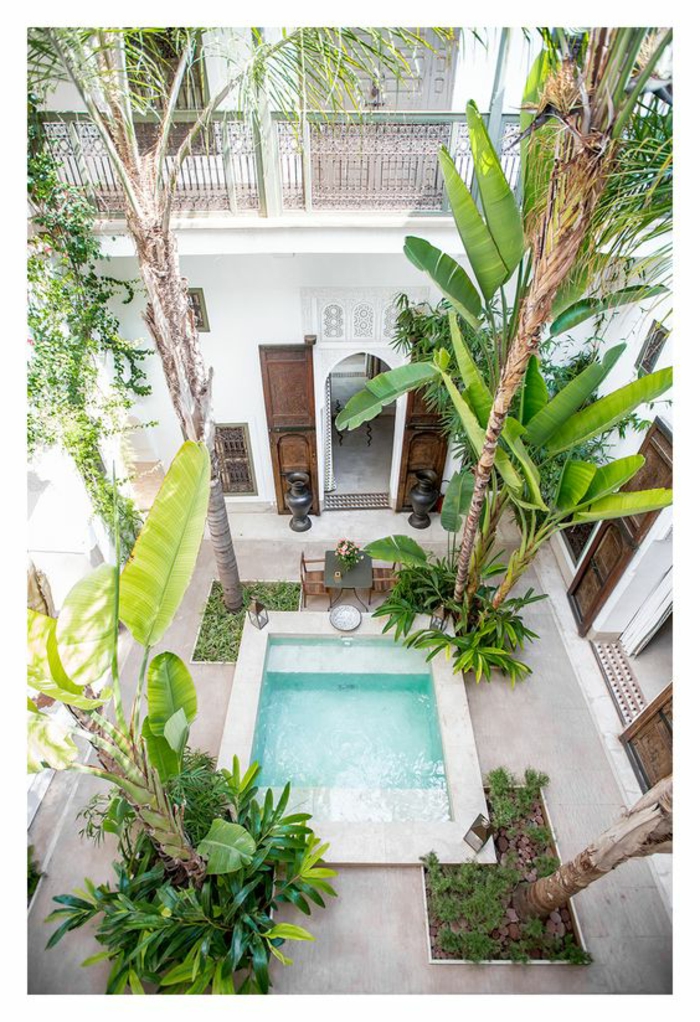 piscina desmontable, patio fotografiado de arriba, palmeras altas, piscina de obra pequeña, edificio alto con balcones