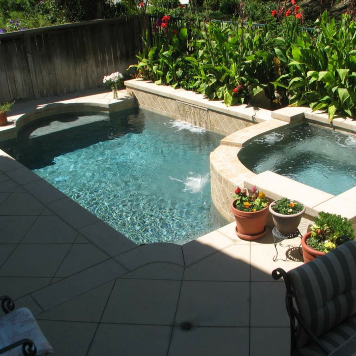 oiscina desmontable, patio con cama de flores, suelo de baldosas, piscina pequeña con dos niveles, macetas con flores