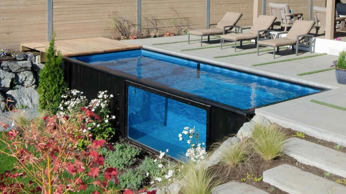 piscinas prefabricadas, piscina hecha de contenedor negro, patio con escaleras, tumbonas beige, plantas