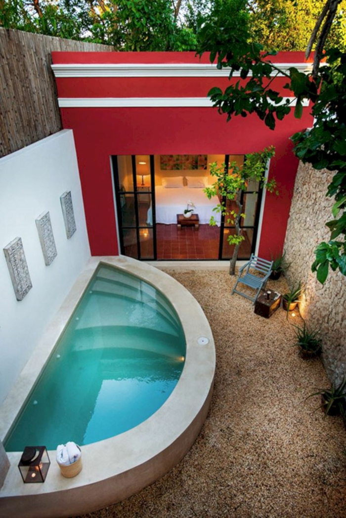 piscinas desmontables, patio con gravilla, casa con pared rojo, piscina en forma de media luna, muros altos