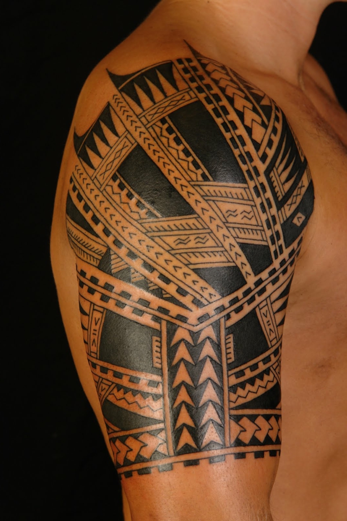 tatuajes hombro, hombre de perfil, tatuaje maori en medio brazo, símbolo polinesio punta de lanza