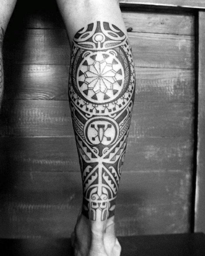 brazalete maori, foto en blanco y negro, tatuaje masculino en pierna inferior, símbolos polinesios maories