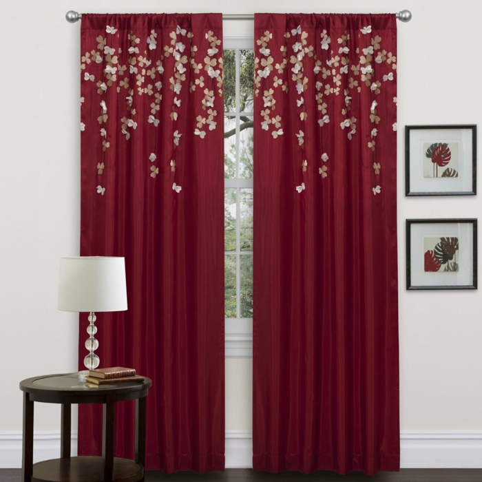 telas cortinas, cortinas clásicas rojas con aplicación de pequeñas flores, mesilla de madera con lámpara blanca