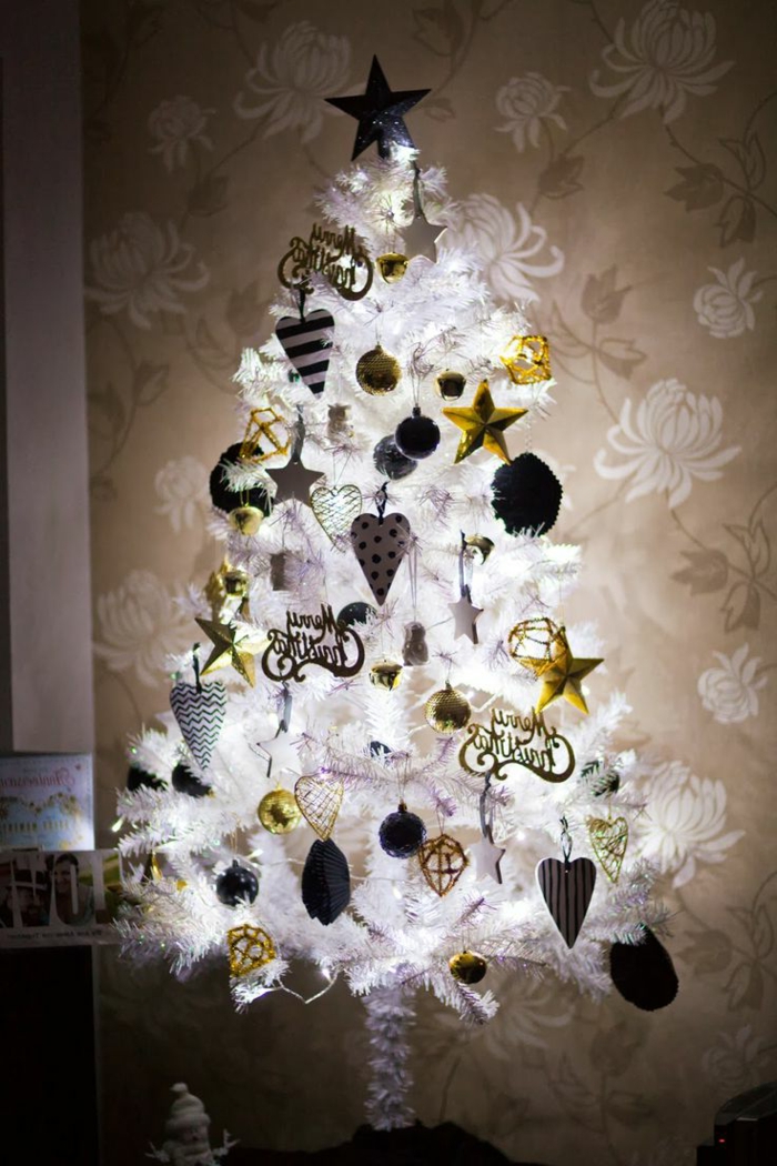 arbol de navidad original muy relumbrante, con adornos en blanco dorado y negro , tapices de papel con flores