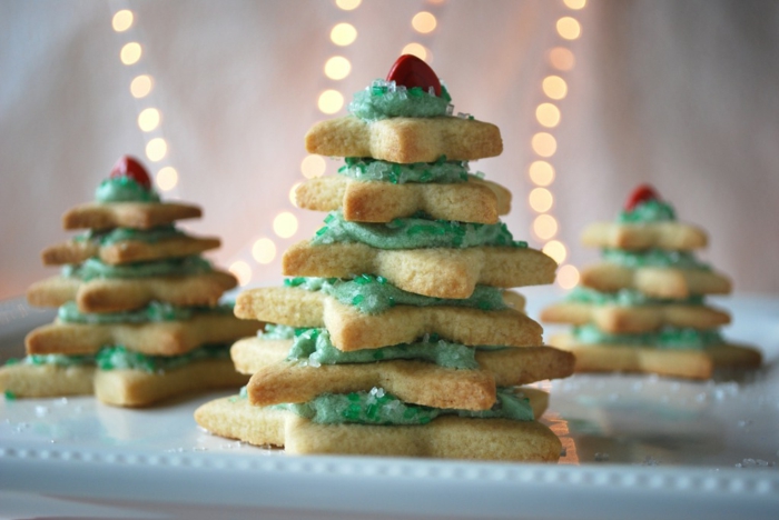 estrellas de navidad, galletas de mantequilla navideñas en forma de estrellas colocados en forma de árbol navideño, betún verde
