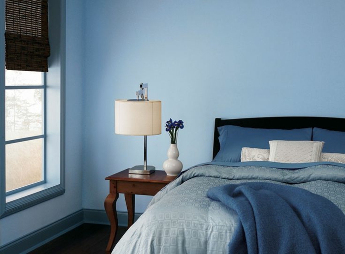decoracion de paredes, habitación en azul atenuado, paredes pintadas, cama matrimonio de madera en negro, cobijas en las matices del azul, mesilla vintage de madera