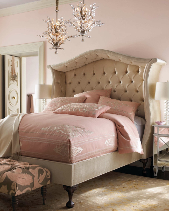 cabeceros de cama originales, cama matrimonio en beige y cobijas en color rosa, dos candelabros estilo clásico y cabezal capitoné con marco