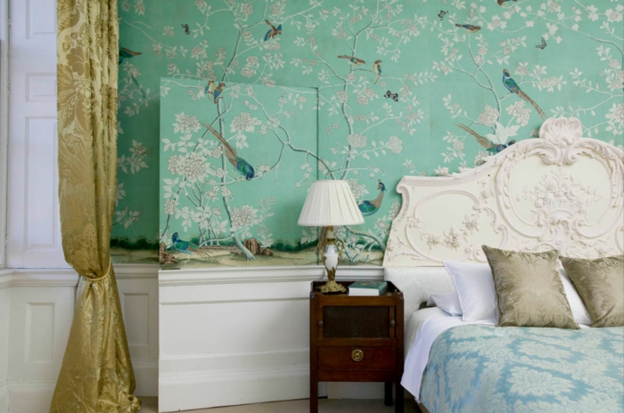 tonos de azul, papel pintado en verde con bonita decoración, cortinas doradas con estampado de flores, cama vintage con cabecero ornamentado