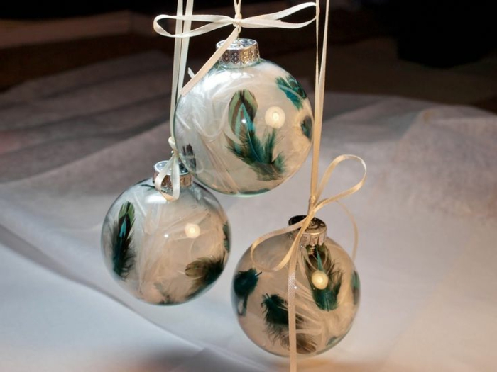decoracion navideña casera, tres bolas de cristal transparentes llenas de plumas blancas y verdes, bonitos elementos para el árbol navideño