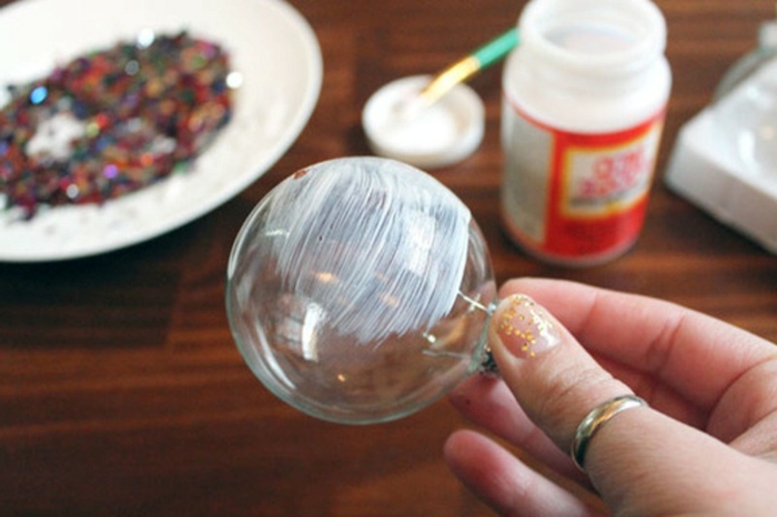 bolas de colores, esfera de vidrio decorada con confeti, pasos para elaborarla, colocar una capa de pegamento en la esfera