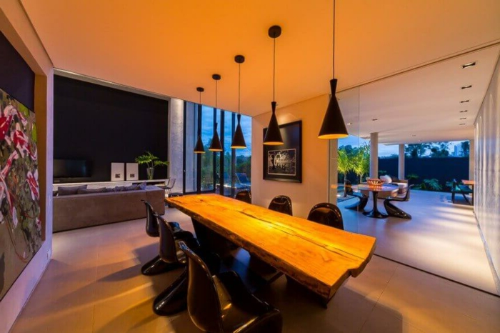 salon comedor, iluminación original para un comedor moderno con mesa alargada de madera y sillas negras modernas, paredes con decoración