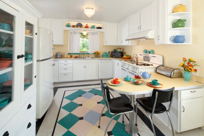 salon cocina, cocina con muebles blancos y detalles en azul y verde, barra oval en l con dos sillas negras