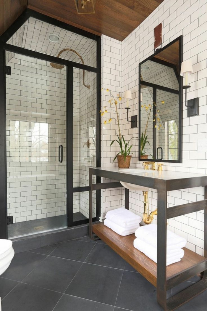 cuartos de baño con ducha, ducha de obra separada con vidrio, techo inclinado, pared con baldosas blancas, espejo grande, mueble bajolavabo