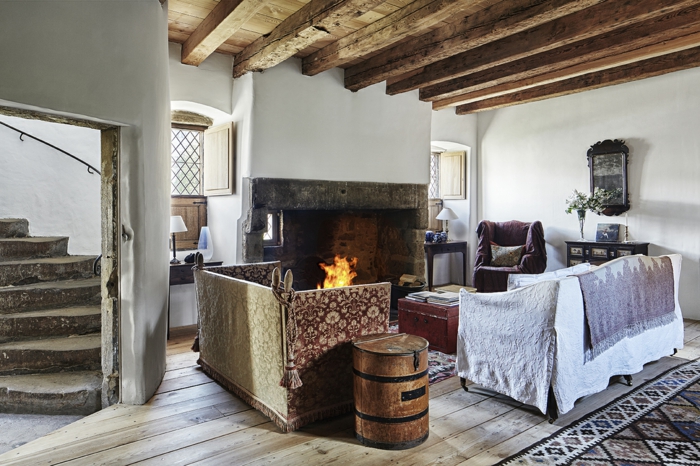 chimeneas rusticasa, espacio en estilo rústico con techo de vigas de madera, sofás vintage y chimenea grande