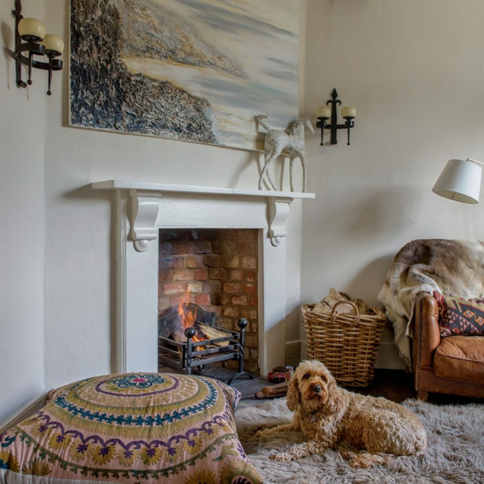 estufa leña, interior bonito en blanco con chimenea acogedora, alfombra peluda y lámparas vintage