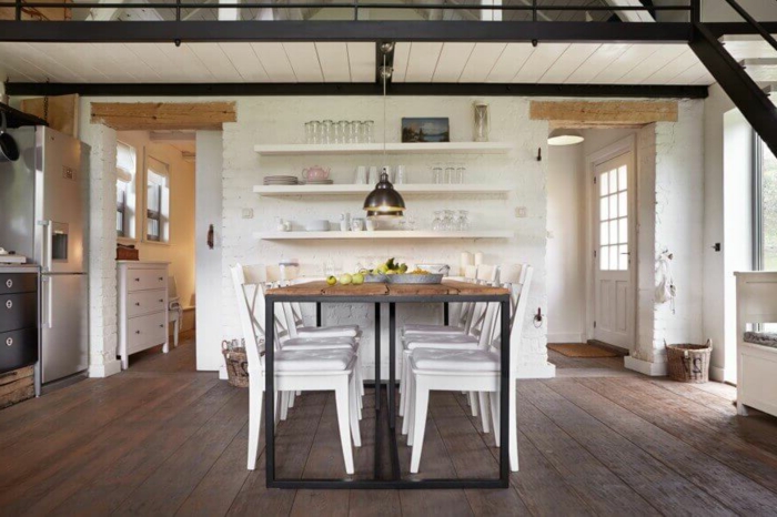 mesas de comedor moderno, cocina en blanco, paredes con ladrillos artificiales, suelo de madera y mesa original de madera y metal