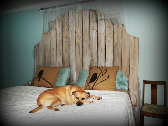 cabezales cama, cabecero en arca de madera, paredes en verde claro, cojines con dibujos orientales, cama doble con pero