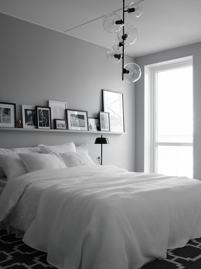 dormitorios modernos, habitación en blanco y gris con lámpara moderna y muchos cuadros decorativos colocados en un estante flotante, habitación en estilo minimalista
