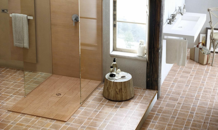 baños pequeños con ducha, baño con mucha luz, ducha de obra con plato de madera, suelo de baldosas, ventana y lavabo blanco