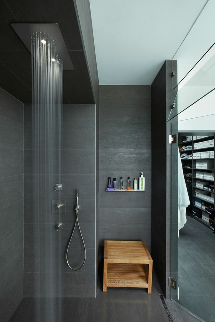 baños pequeños con ducha, baño moderno negro con banco de amdera. ducha de obra con efecto de lluvia y ducha de mano, suelo laminado