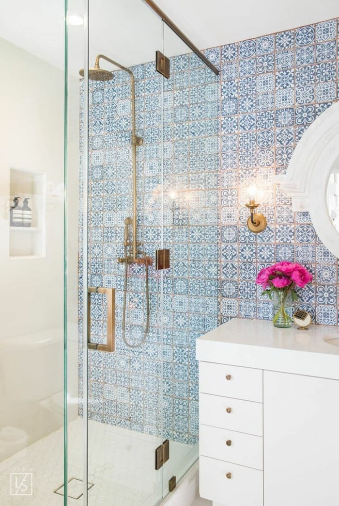 duchas modernas, baño pequeño con azulejos en tonos azules, ducha de obra con puerta de vidrio, palto de ducha, mueble blanco