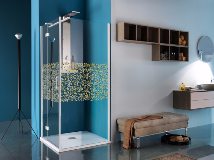 duchas de obra, cabina de cucha transparente con decoración en amarillo y azul, paredes en azul y blanco, banco tapizado