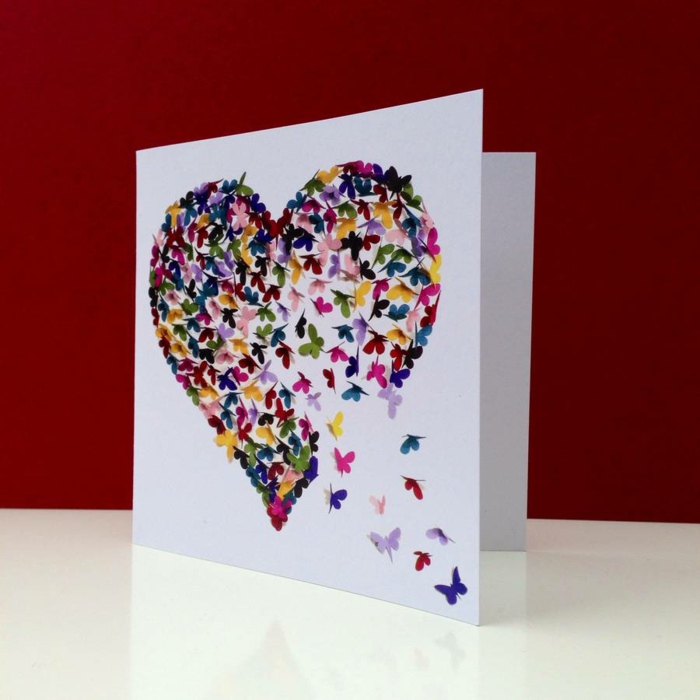 tarjetas de cumpleaños, tarjeta romámtica de cumpleaños con corazón de mariposas pegadas sobre papel blanco