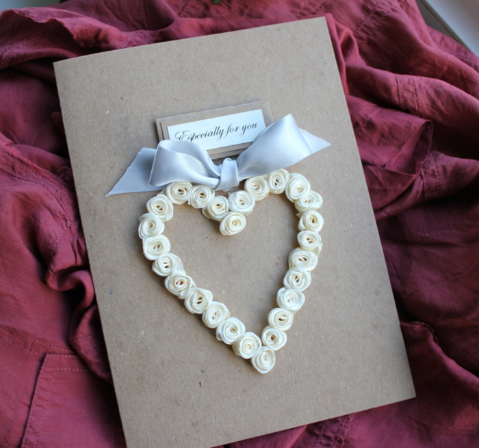 tarjetas de cumpleaños, tarjeta romántica con lazo de cinta plateada y corazón hecho de rosas blancas pequeñas