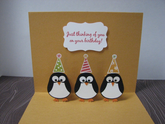 tarjetas de cumpleaños originales, tarjeta de cumpleaños troquelada de papel kraft con pinguinos con gorritos de fiesta