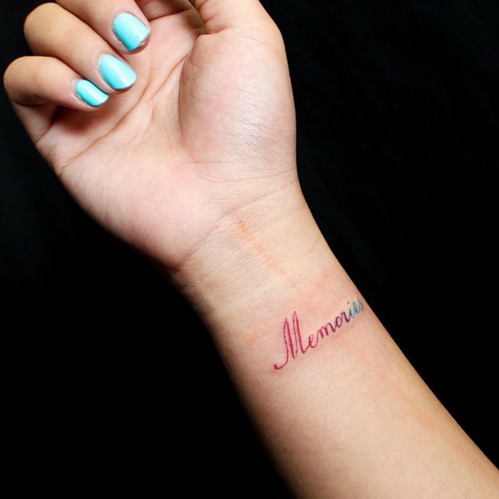 tipos de letras para tatuajes, antebrazo de mujer con esmalte azul, tatuaje con palabra de color delicado