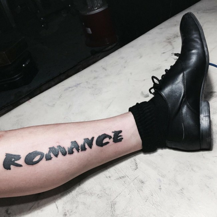 tatuajes de nombres, tatuaje con letras en negro sólido, parte inferior de la pierna con calzado y calcetín negro