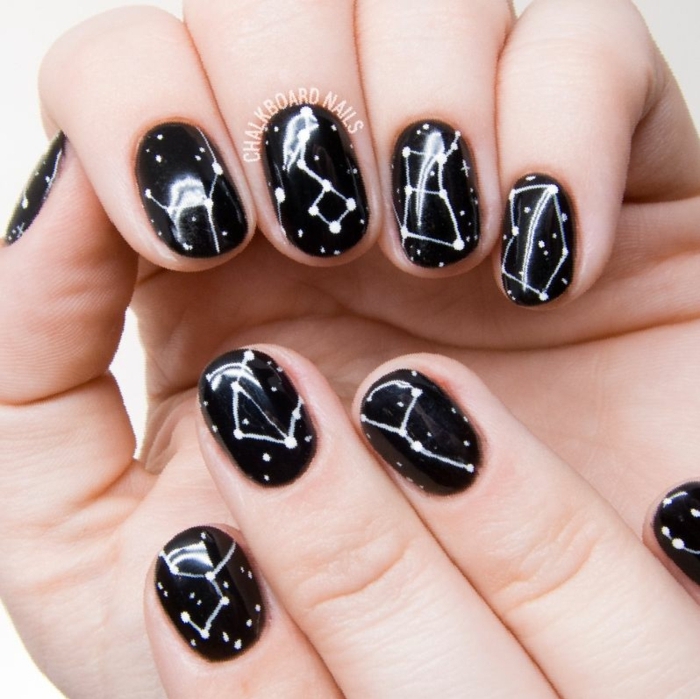 fotos de uñas pintadas, uñas en negro con decoración original en blanco con los signos del zodíaco 