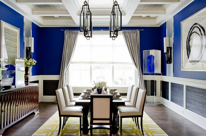 comedor moderno, comedor espacioso, con mesa de madera y sillas tapizadas con piel en el centro, paredes en azul oscuro, lámparas modernas en el techo