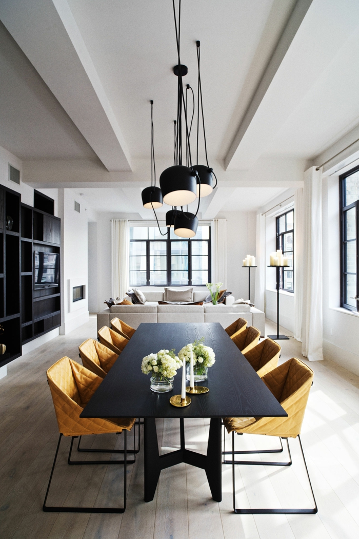 comedores, salón alargado con paredes blancas, comedor con mesa negra y sillas modernas en color ocre