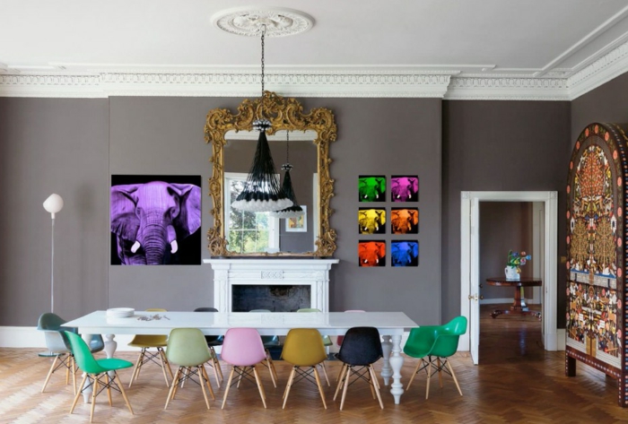 comedor, propuesta actual y atrevida con cuadros modernistas, grande espejo vintage en dorado y pequeñas sillas en diferentes colores