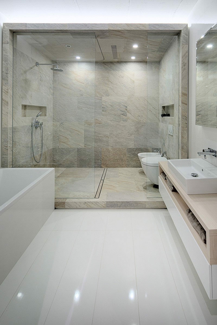 platos de ducha de obra, baño grande con suelo laminado, bañera rectangular, ducha de obra con mampara de vidrio, paredes de baldosas