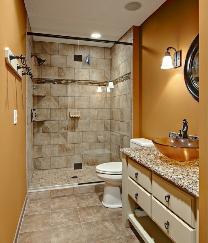 baños pequeños con ducha, baño con encimera de granito, suelo de baldosas, paredes en ocre, ducha de obra con mampara de vidrio