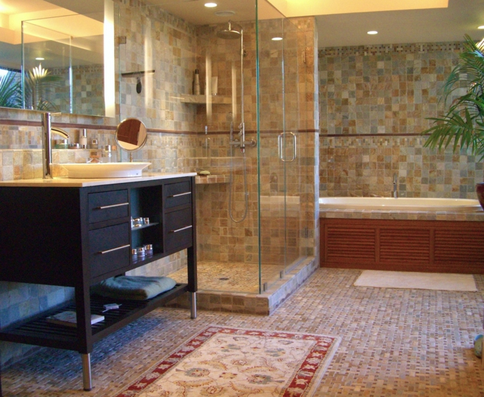 suelos para baños, baño grande con bañera y ducha de obra, paredes con azulejos, espejo grande, ducha de obra con estantes y paredes de vidrio, tapetes y palmera