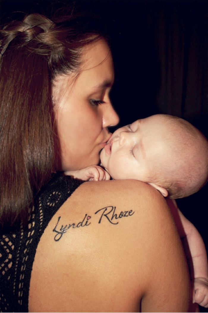 letras tatuajes, mamá y bebé, mujer con tatuaje en el omoplato, nombre de niño Liyndi Rhoze con corazon