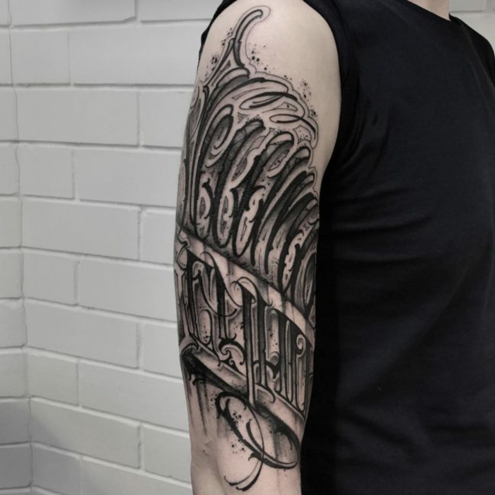 tatuajes frases, hombre con camiseta negra, tatuaje grande en el brazo, frase en blanco y negro, letras grandes estilo grafiti