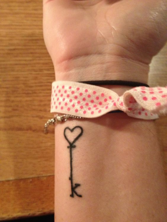 tatuajes letras, tatuaje delicado para mujer, muñeca con tatuaje de letra K y corazon en negro, pulseras