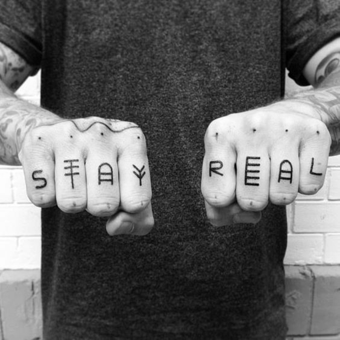 tatuajes frases, hombre con ocho dedos tatuados, cada dedo con una letra, foto en blanco y negro 