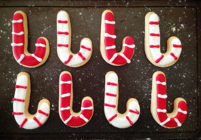 receta de galletas de mantequilla, galletas simpáticas en blanco y rojo en forma de bastón, decoradas con glaseado real