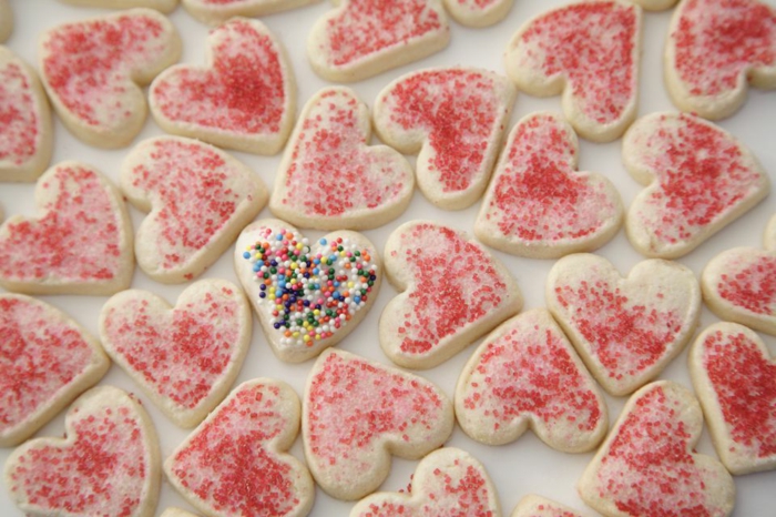 receta de galletas de mantequilla, pequeñas galletas en forma de corazón con chispas de azúcar en diferentes colores