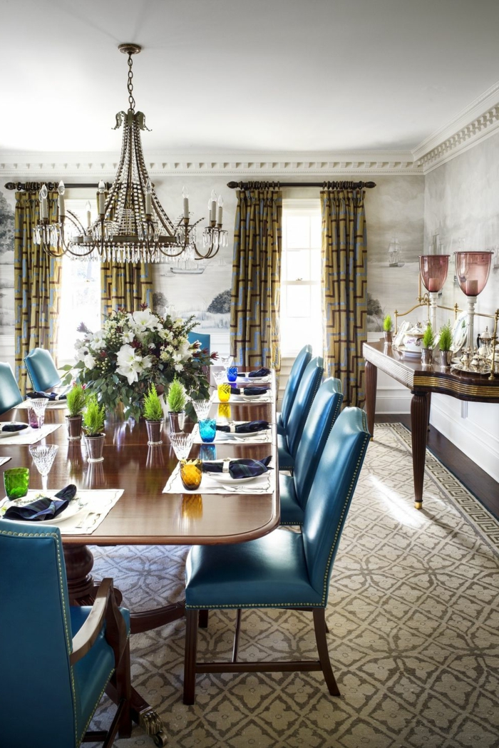 centros de mesa, comedor en estilo clásico, grande ramo de flores en el centro de la mesa, pinos enanos, grande candelabro y sillas tapizadas en azul 