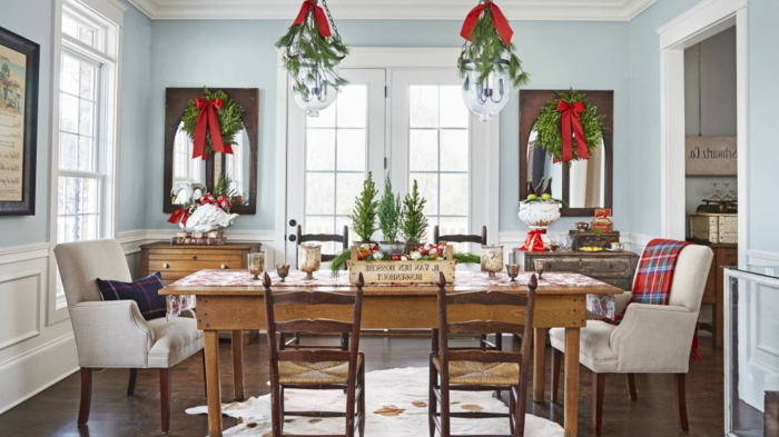 centros de mesa, decoracion tradicional en verde y rojo, coronas de navidad colgadas en las ventanas con grandes cintas rojas, muebles de madera